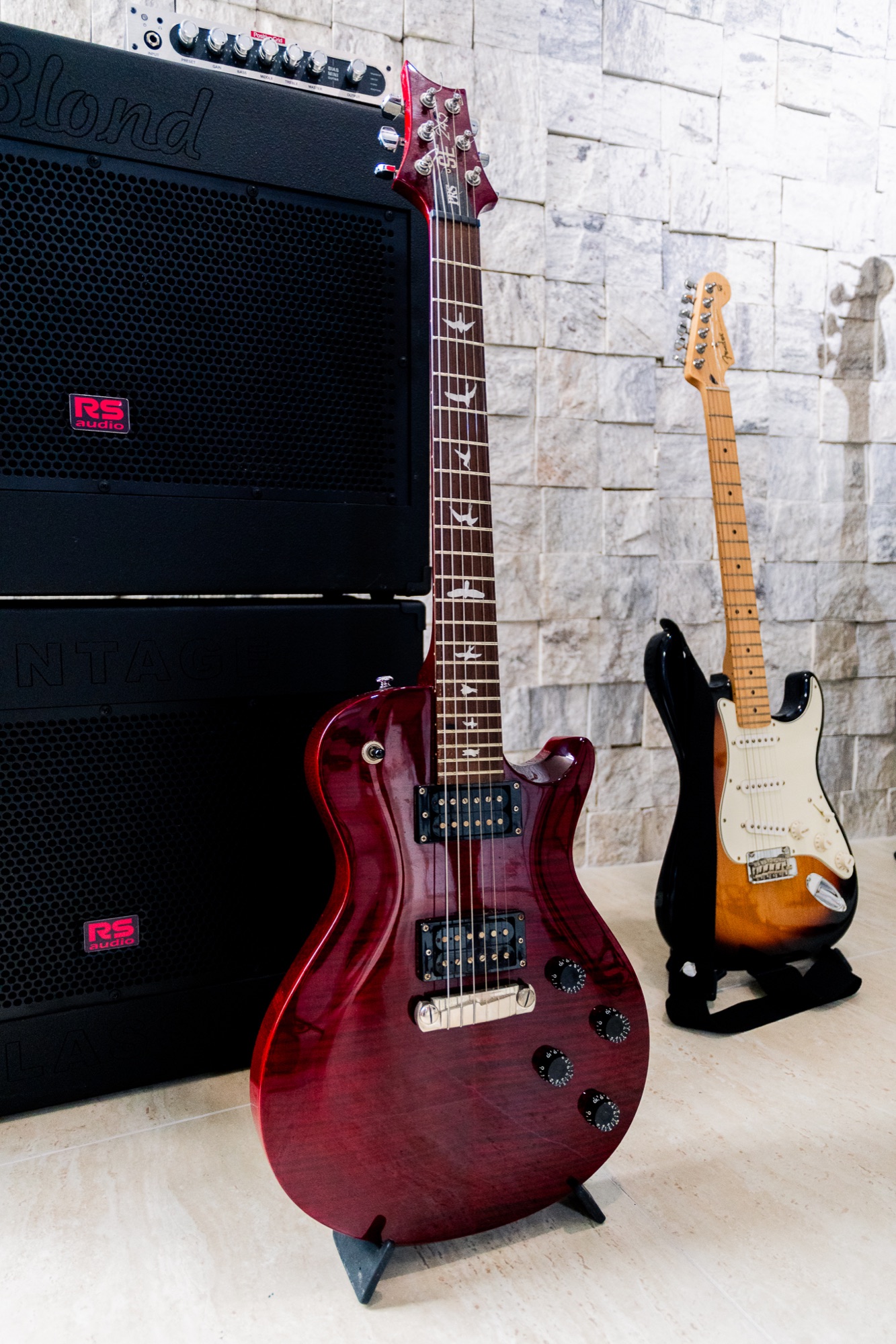 Guitarras apoiadas diante dos amplificadores do Kras