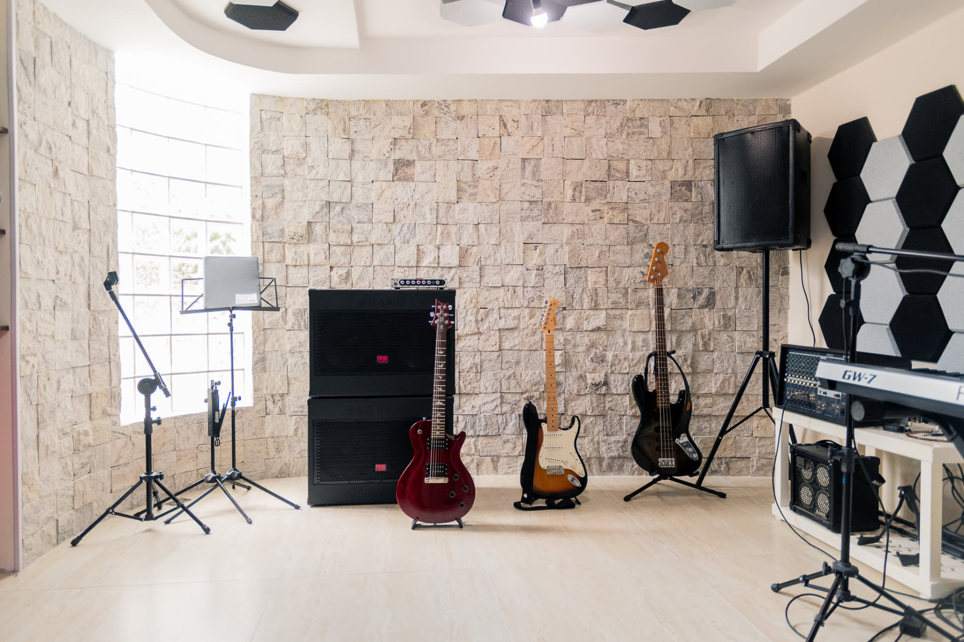 Guitarras, baixo, amplificadores e teclado na sala do Kras